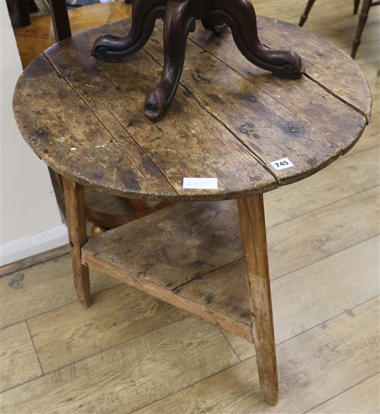 An early 19th century pine circular topped two tier cricket table, H.69cm